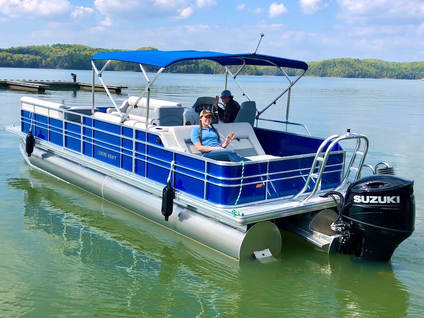 Photo of people waving from a pontoon